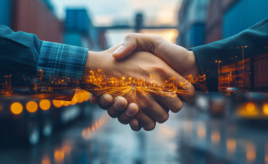 Handshaking between business partners amid bustling international logistics transportation hub at twilight