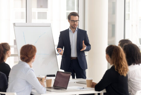 Male business coach speaker in suit give flipchart presentation