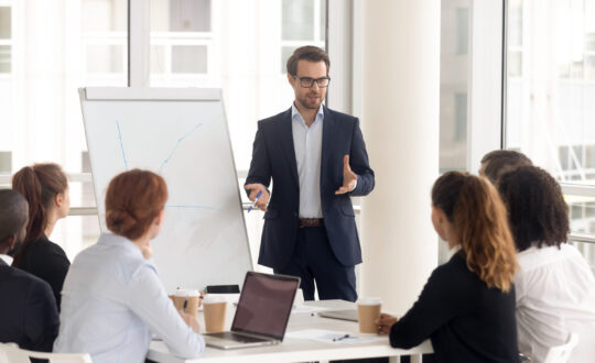 Male business coach speaker in suit give flipchart presentation