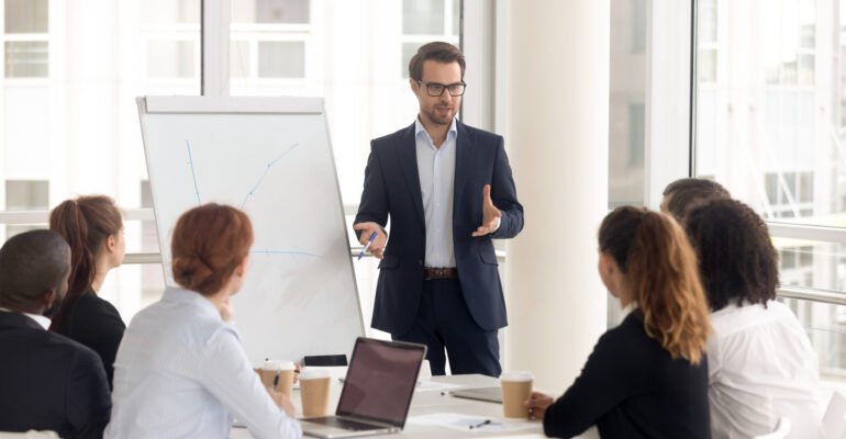 Male business coach speaker in suit give flipchart presentation