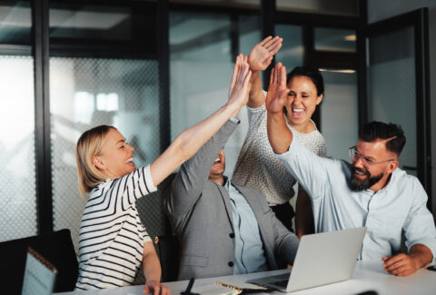 Businesspeople high-fiving at work