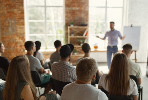 Male speaker giving presentation in hall at university workshop